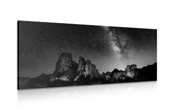 Obraz rozgwieżdżone niebo nad skałami w wersji czarno-białej